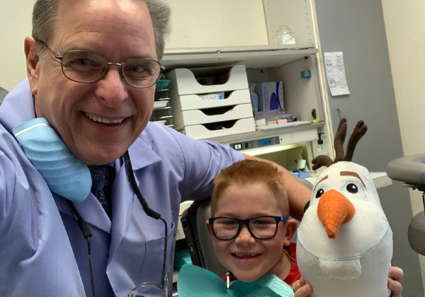 Dr. and a young patient with a stuffed goose.